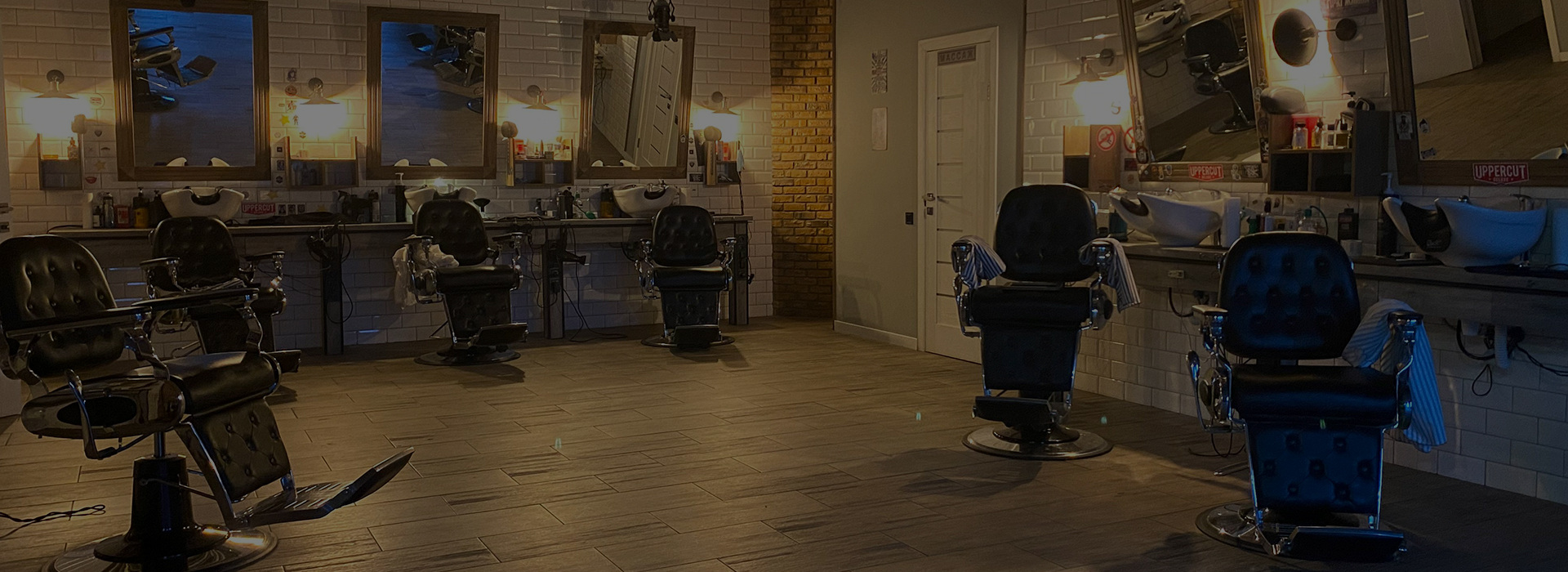 Empty barbershop with black leather barber chairs and mirrors